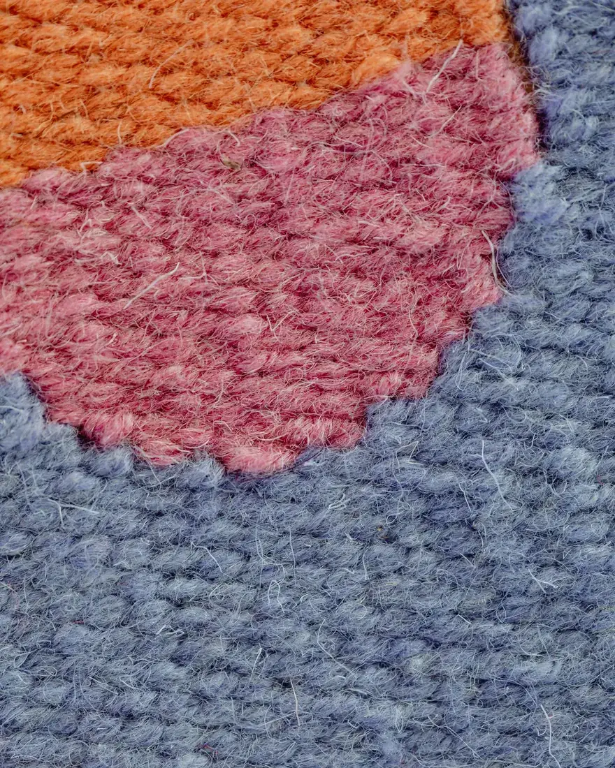Detalle de un tejido de lana con campos de color contiguos y transiciones dentadas entre tonos